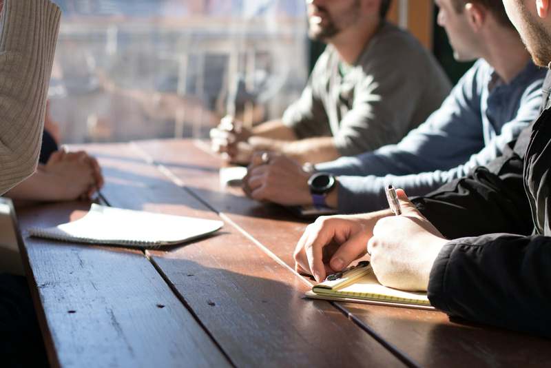 Business-casual colleagues reviewing documents around a table