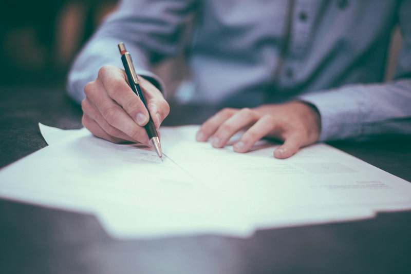 A person reviewing and signing contract documents